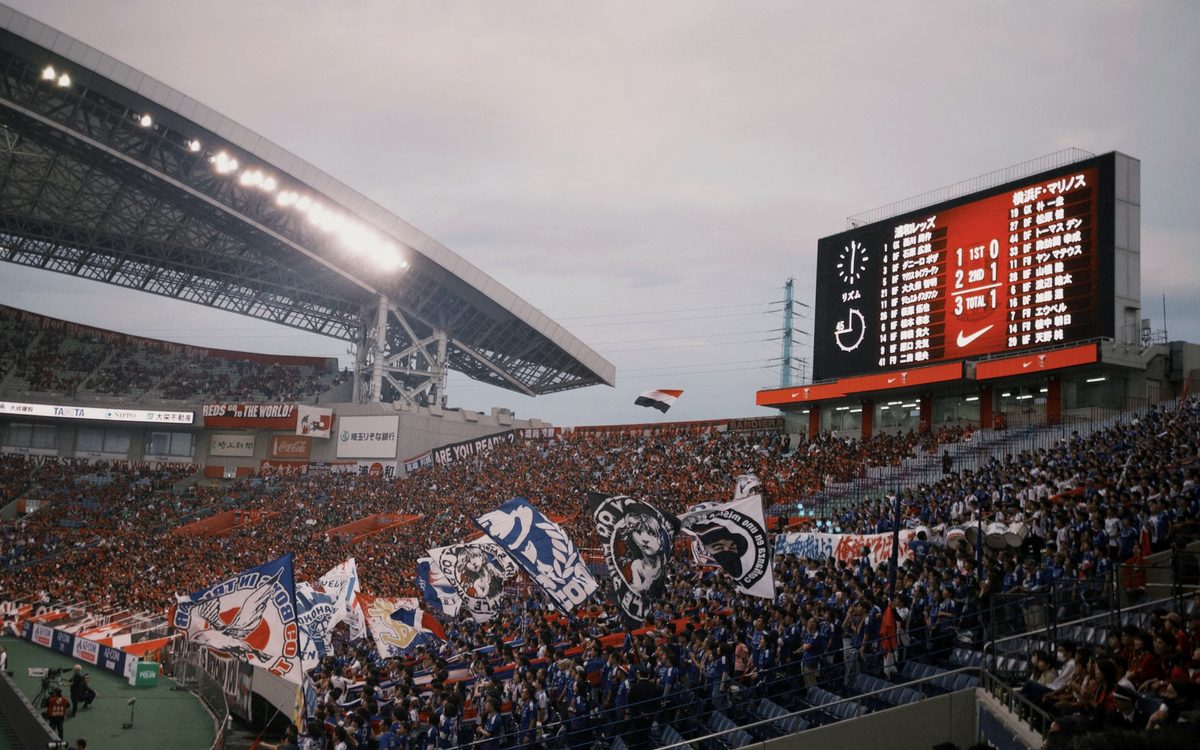 Packed stadium crowd with flags during a large sporting event