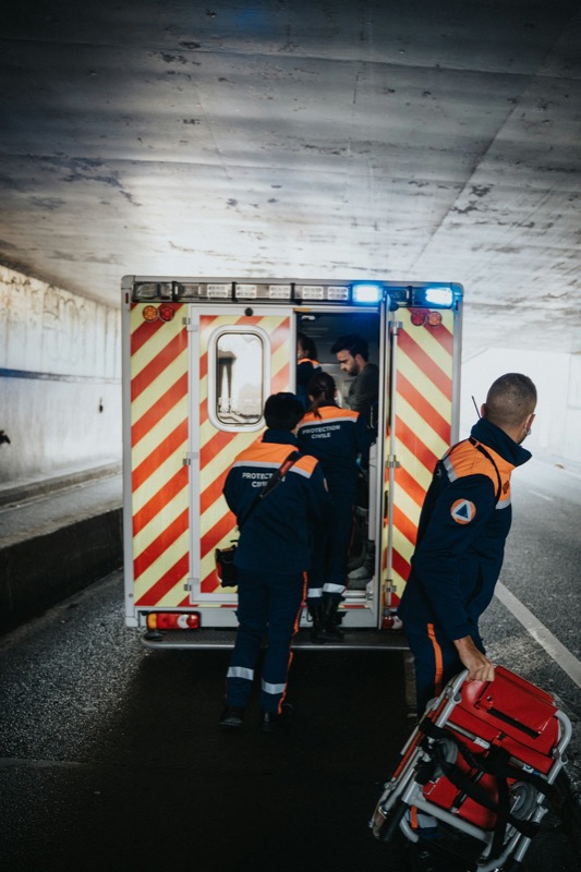 Paramedic team loading a patient into an ambulance